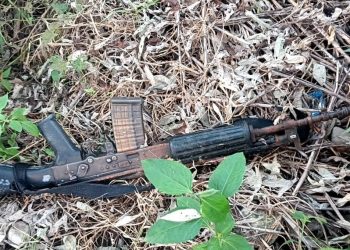 A recovered INSAS rifle with magazine and 19 live rounds, and 2 spent rounds, lies abandoned in a bushy area with dry leaves and twigs, near Sugam Shanti Tol, Wirtamod, Jhapa.