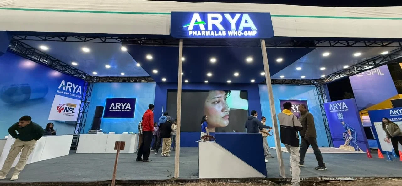एनपीएलको स्वास्थ्य साझेदार बनेको आर्य फार्माल्याबको लोगो र क्रिकेट मैदान